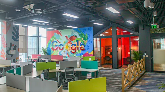 A workspace with the Google logo and desks.
